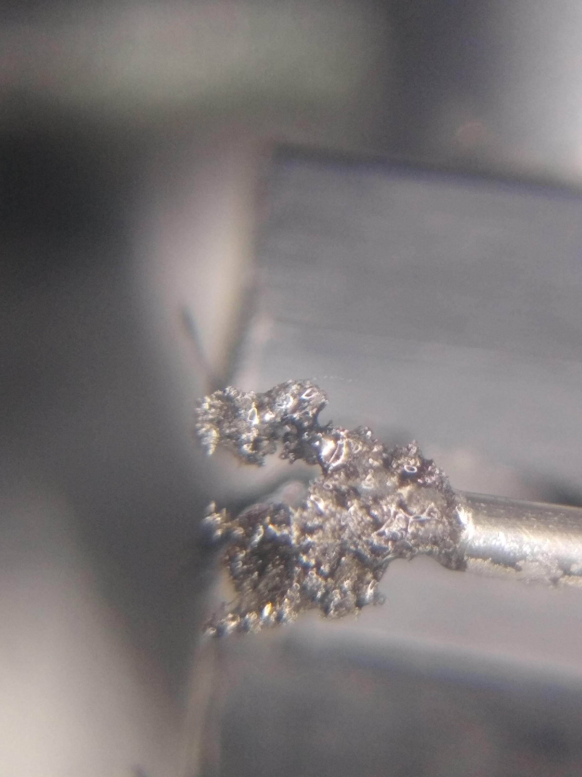 Microscopic view of metal particle sintering showing consolidated metal structure